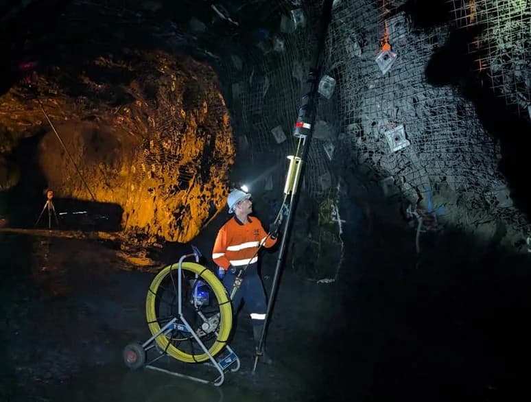 IBT surveyor lining up the feeder pole under an up-hole in an underground drive