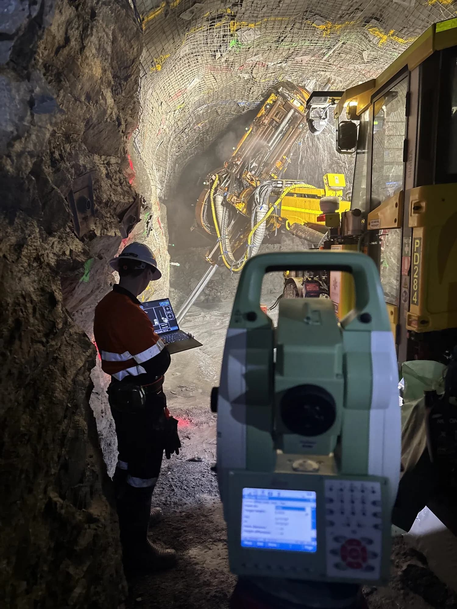 An engineer working from a laptop beside a total station in an underground drive