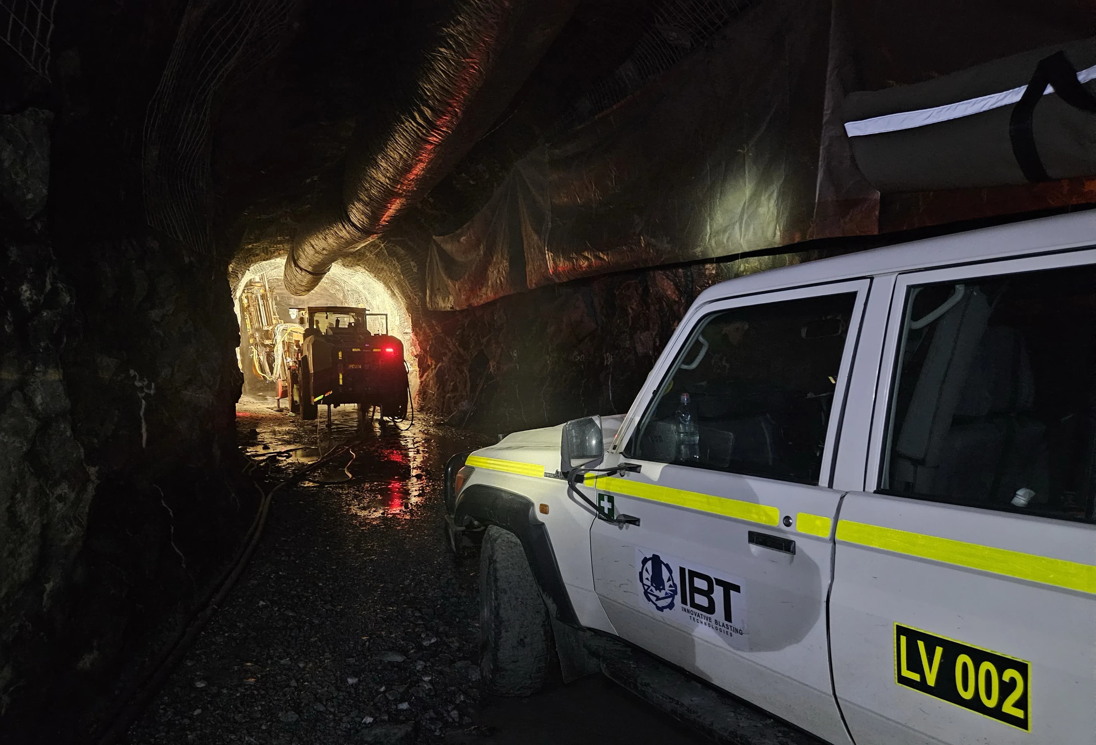 IBT survey ute LV 002 in an underground drive, a loader's lights further down